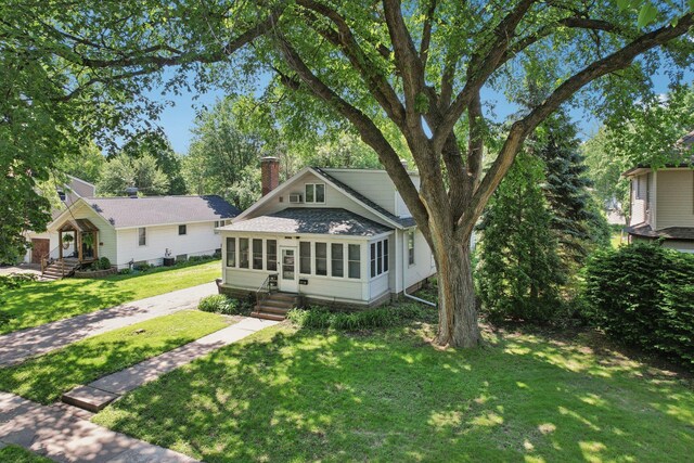 1384 Midway Pkwy, Saint Paul, MN 55108 - bungalow-style home with a front yard, a chimney, driveway, entry steps, and roof with shingles