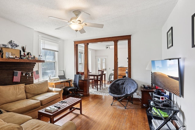 1384 Midway Pkwy, Saint Paul, MN 55108 - living room featuring a ceiling fan, hardwood / wood-style floors, a textured ceiling, and decorative columns
