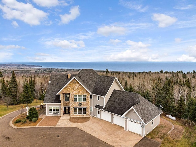 969 Deerview Ln, Two Harbors, MN 55616 - view of front facade with stone siding, driveway, a chimney, and roof with shingles