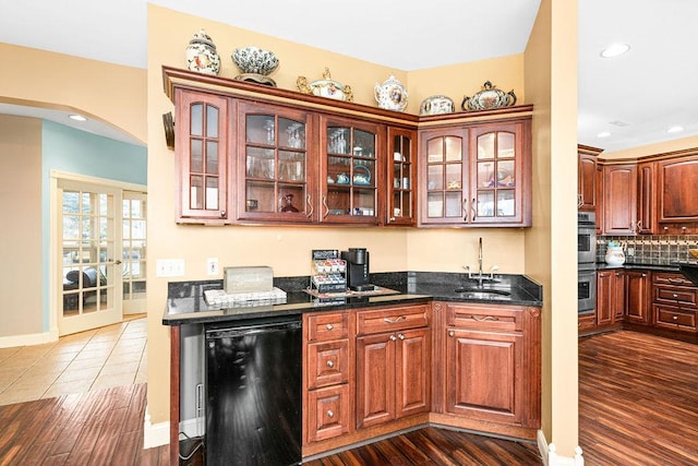 969 Deerview Ln, Two Harbors, MN 55616 - kitchen with arched walkways, glass insert cabinets, fridge, dark wood-type flooring, and backsplash