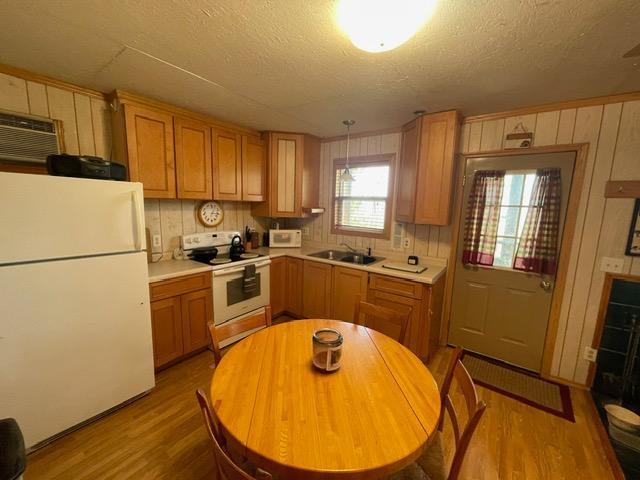 4716 Big Rice Lake Rd NE, Thunder Lake Twp, MN 56672 - kitchen featuring white appliances, wood finished floors, a textured ceiling, light countertops, and a sink