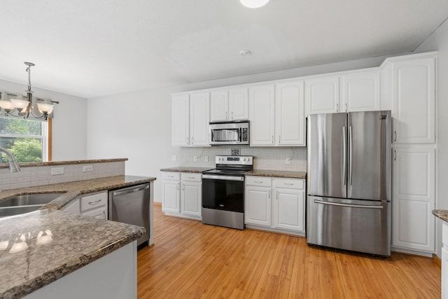 6701 Urbandale Ln N, Maple Grove, MN 55311 - kitchen with appliances with stainless steel finishes, light wood finished floors, backsplash, a chandelier, and white cabinets