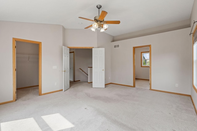 6701 Urbandale Ln N, Maple Grove, MN 55311 - unfurnished bedroom with vaulted ceiling, light carpet, a walk in closet, and ceiling fan