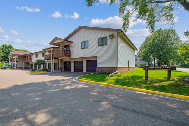4004 Foss Rd Unit 101, Saint Anthony, MN 55421 - view of front of property with a garage, a front lawn, brick siding, and driveway