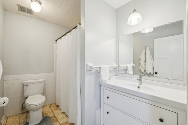 4004 Foss Rd Unit 101, Saint Anthony, MN 55421 - full bathroom with vanity, tile walls, a textured ceiling, a wainscoted wall, and a shower with shower curtain