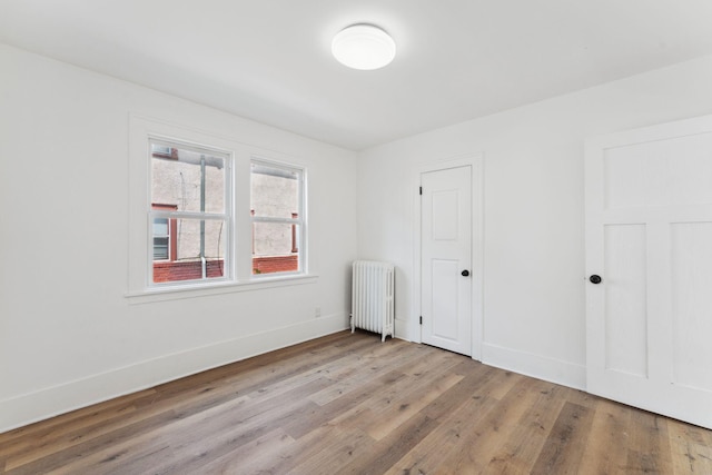 987 Dayton Ave, Saint Paul, MN 55104 - unfurnished bedroom featuring radiator, wood finished floors, and baseboards
