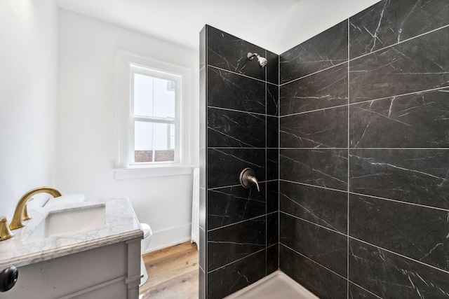 987 Dayton Ave, Saint Paul, MN 55104 - bathroom with a tile shower, wood finished floors, toilet, and vanity