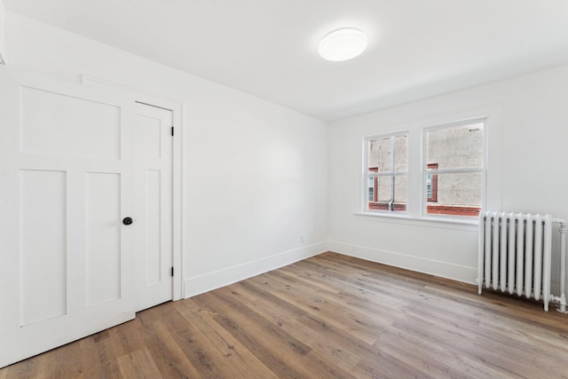 987 Dayton Ave, Saint Paul, MN 55104 - unfurnished bedroom featuring radiator, wood finished floors, and baseboards