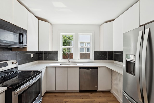 987 Dayton Ave, Saint Paul, MN 55104 - kitchen featuring stainless steel appliances, a sink, light countertops, and decorative backsplash