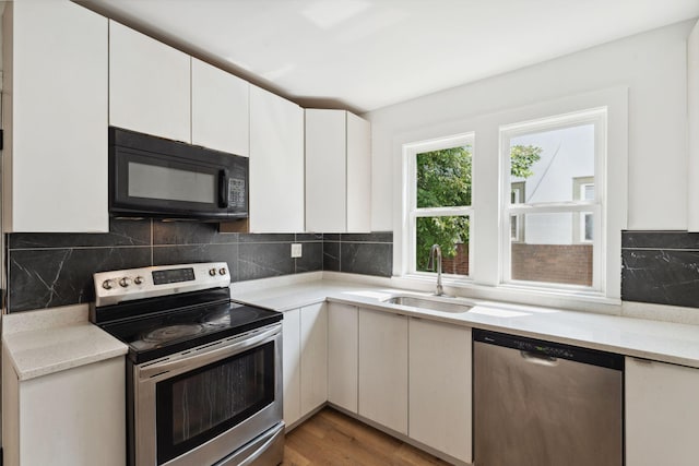 987 Dayton Ave, Saint Paul, MN 55104 - kitchen featuring stainless steel appliances, a sink, white cabinetry, and decorative backsplash