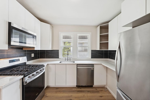 987 Dayton Ave, Saint Paul, MN 55104 - kitchen with stainless steel appliances, open shelves, a sink, light countertops, and backsplash