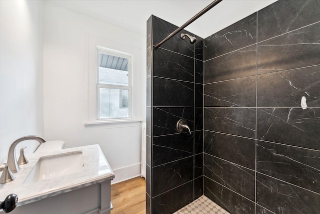 987 Dayton Ave, Saint Paul, MN 55104 - bathroom featuring tiled shower, vanity, wood finished floors, and baseboards