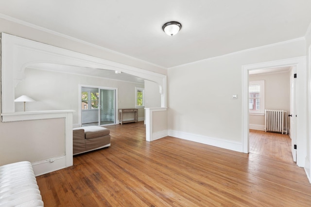 987 Dayton Ave, Saint Paul, MN 55104 - living room with radiator, healthy amount of natural light, light wood-type flooring, crown molding, and baseboards