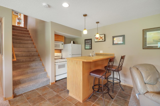 13589 Birch Rd, Rogers, MN 55374 - kitchen featuring white appliances, a peninsula, a breakfast bar, a textured ceiling, and dark tile patterned floors