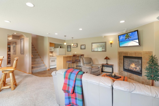 13589 Birch Rd, Rogers, MN 55374 - living area featuring recessed lighting, light carpet, bar, a tiled fireplace, and a textured ceiling