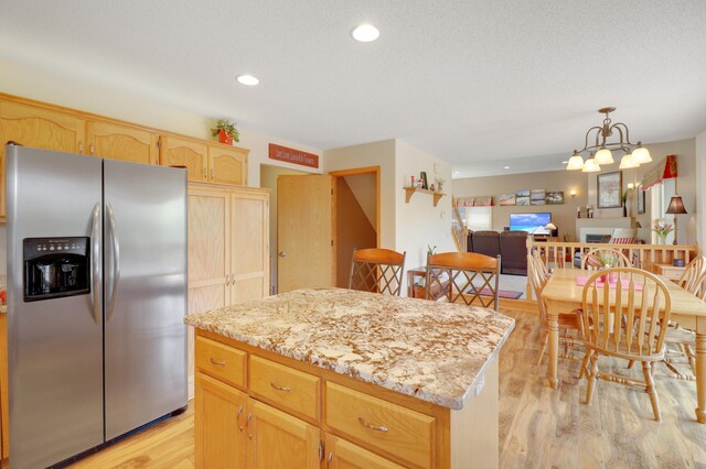 13589 Birch Rd, Rogers, MN 55374 - kitchen with stainless steel fridge with ice dispenser, light wood-type flooring, a kitchen island, light brown cabinets, and open floor plan