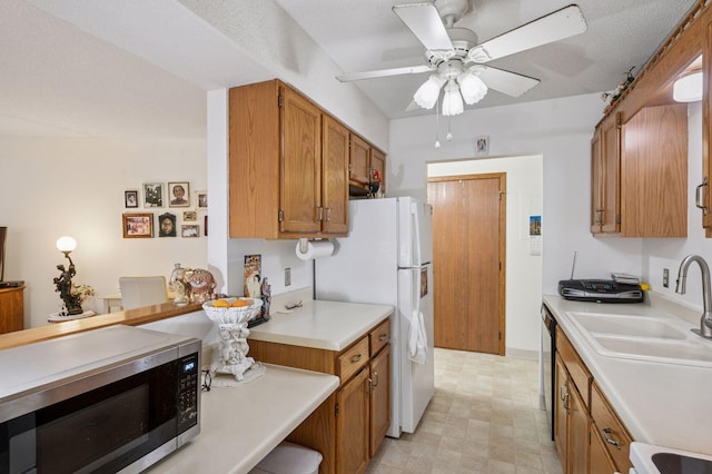 2601 Kenzie Ter Unit 402, Saint Anthony, MN 55418 - kitchen featuring stainless steel microwave, brown cabinetry, light countertops, a ceiling fan, and freestanding refrigerator
