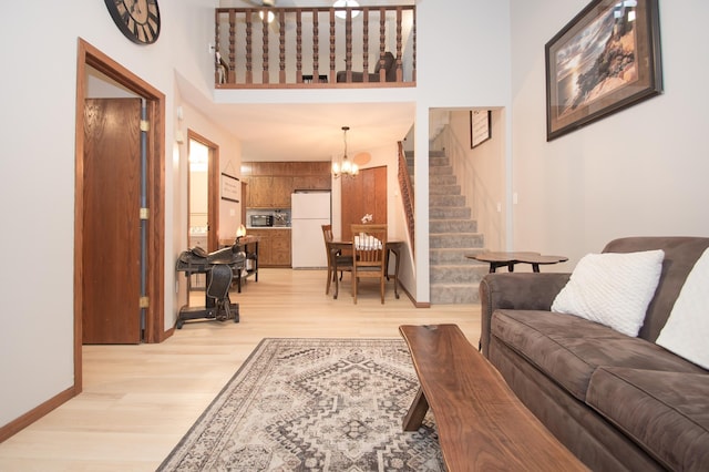 544 Auburn Pl NW Unit H, Elk River, MN 55330 - living room featuring stairs, light wood-type flooring, a chandelier, and a towering ceiling