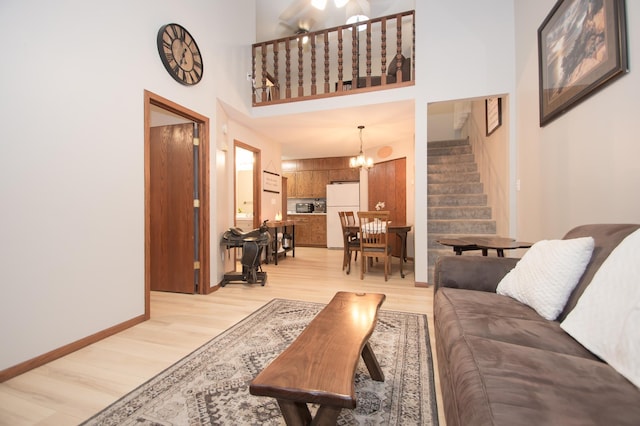 544 Auburn Pl NW Unit H, Elk River, MN 55330 - living room featuring a towering ceiling, stairway, light wood finished floors, and a chandelier