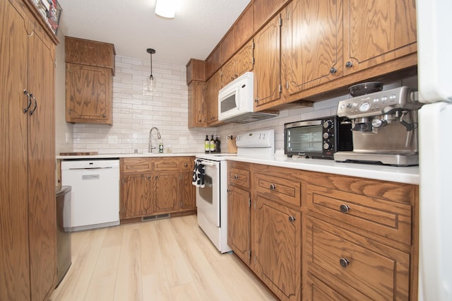 544 Auburn Pl NW Unit H, Elk River, MN 55330 - kitchen with white appliances, brown cabinets, tasteful backsplash, light wood finished floors, and light countertops