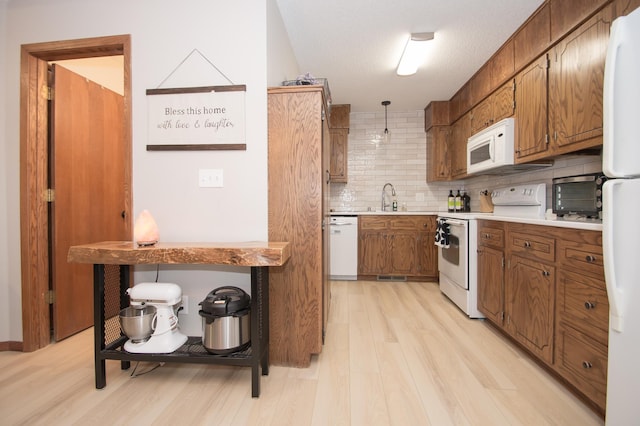544 Auburn Pl NW Unit H, Elk River, MN 55330 - kitchen with white appliances, brown cabinets, tasteful backsplash, light wood-style floors, and light countertops