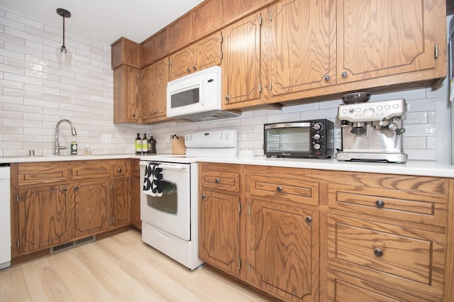 544 Auburn Pl NW Unit H, Elk River, MN 55330 - kitchen featuring white appliances, backsplash, brown cabinetry, and light countertops
