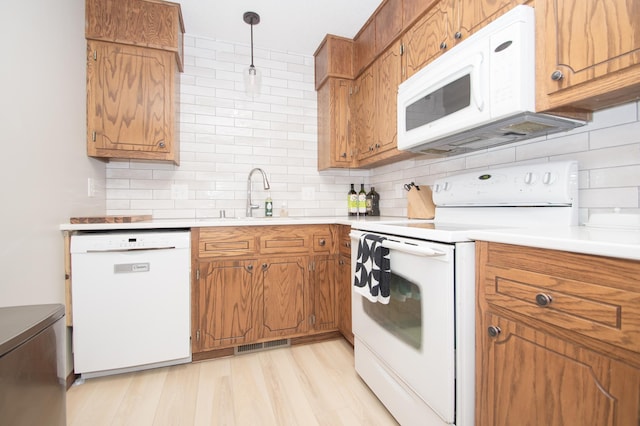 544 Auburn Pl NW Unit H, Elk River, MN 55330 - kitchen with white appliances, brown cabinets, tasteful backsplash, and light countertops