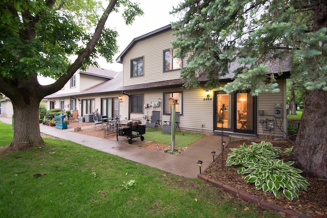 544 Auburn Pl NW Unit H, Elk River, MN 55330 - back of property with a lawn, a patio area, and roof with shingles
