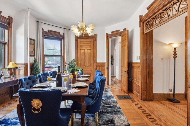 1601 Park Ave, Minneapolis, MN 55404 - dining room with a chandelier, a wainscoted wall, and light wood-style floors
