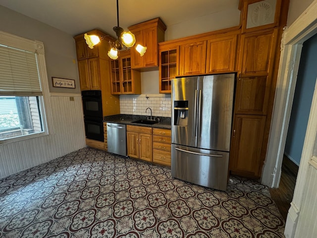 1601 Park Ave, Minneapolis, MN 55404 - kitchen with appliances with stainless steel finishes, dark countertops, brown cabinetry, wainscoting, and backsplash