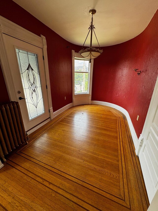 1601 Park Ave, Minneapolis, MN 55404 - unfurnished dining area featuring radiator heating unit and wood finished floors
