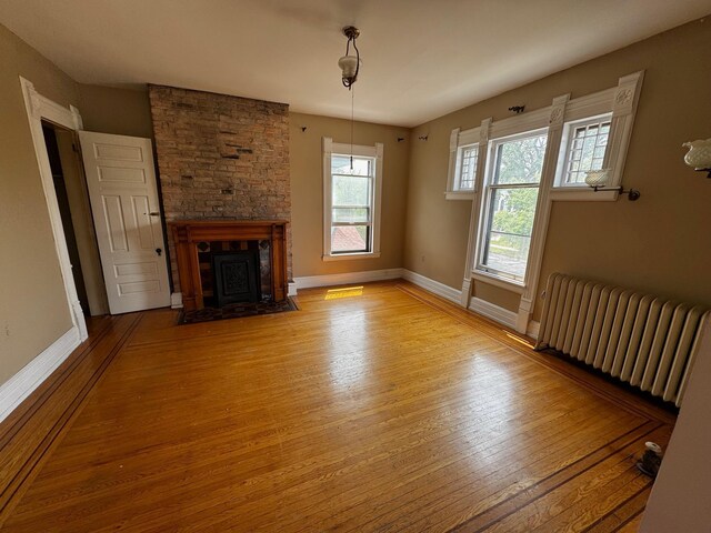 1601 Park Ave, Minneapolis, MN 55404 - unfurnished living room with radiator heating unit, wood finished floors, and a fireplace with flush hearth