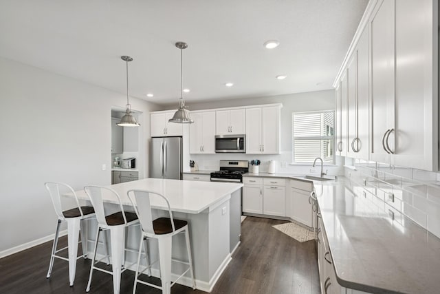 11604 Brayburn Trl, Dayton, MN 55369 - kitchen featuring stainless steel appliances, a kitchen island, dark wood-style flooring, recessed lighting, and white cabinetry