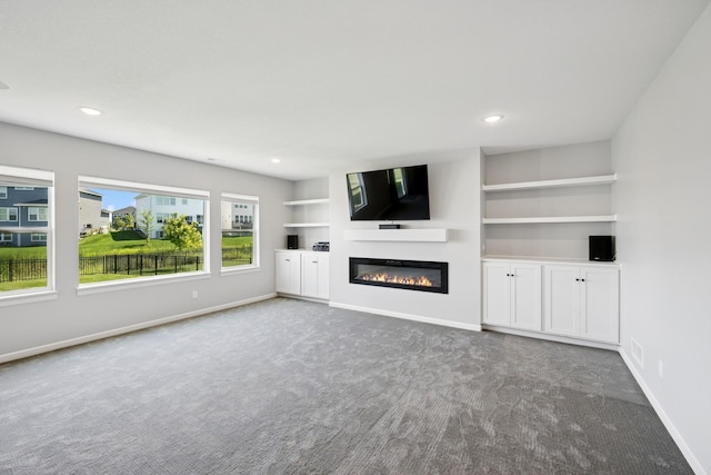 11604 Brayburn Trl, Dayton, MN 55369 - unfurnished living room featuring carpet flooring, a glass covered fireplace, built in shelves, and recessed lighting