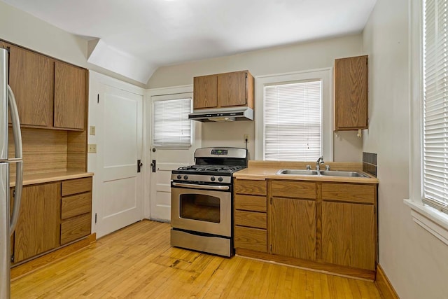 67 Lowry Ave NE, Minneapolis, MN 55418 - kitchen with appliances with stainless steel finishes, under cabinet range hood, brown cabinets, light wood-style flooring, and light countertops
