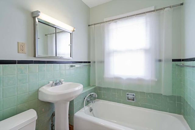 67 Lowry Ave NE, Minneapolis, MN 55418 - full bath featuring tile walls, a bath, and wainscoting