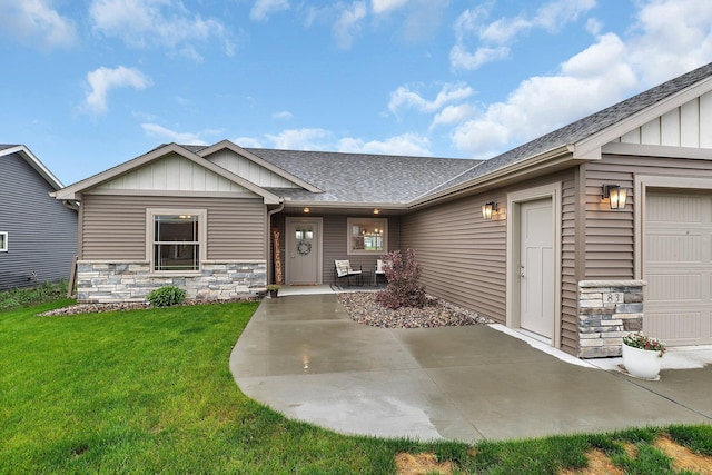 83 Meadow Ln, Cold Spring, MN 56320 - view of front facade with board and batten siding, roof with shingles, an attached garage, and a front lawn