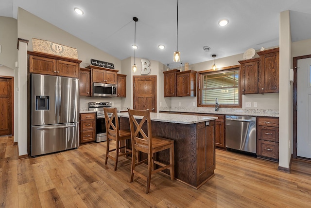83 Meadow Ln, Cold Spring, MN 56320 - kitchen with stainless steel appliances, light wood-style floors, vaulted ceiling, a center island, and a kitchen breakfast bar