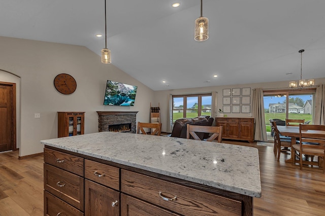 83 Meadow Ln, Cold Spring, MN 56320 - kitchen featuring vaulted ceiling, a stone fireplace, a chandelier, light wood-style floors, and open floor plan