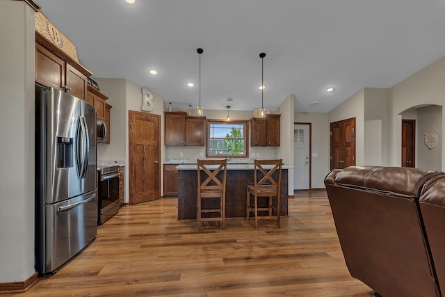 83 Meadow Ln, Cold Spring, MN 56320 - kitchen with stainless steel appliances, open floor plan, arched walkways, light wood-type flooring, and lofted ceiling