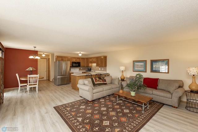 2383 58th Ave S Unit A, Fargo, ND 58104 - living area featuring a chandelier, light wood finished floors, and a textured ceiling