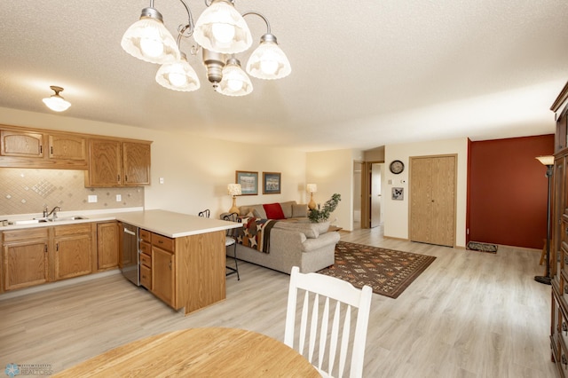 2383 58th Ave S Unit A, Fargo, ND 58104 - kitchen featuring stainless steel dishwasher, a peninsula, light wood-style flooring, and light countertops