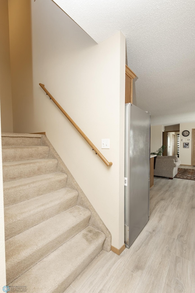 2383 58th Ave S Unit A, Fargo, ND 58104 - stairs with wood finished floors and a textured ceiling