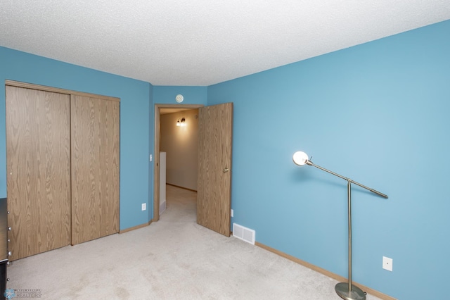 2383 58th Ave S Unit A, Fargo, ND 58104 - unfurnished bedroom with carpet flooring, a closet, and a textured ceiling