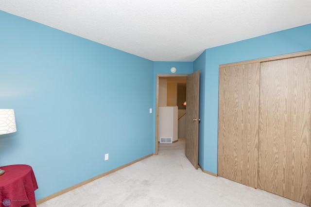 2383 58th Ave S Unit A, Fargo, ND 58104 - unfurnished bedroom featuring carpet, a closet, and a textured ceiling