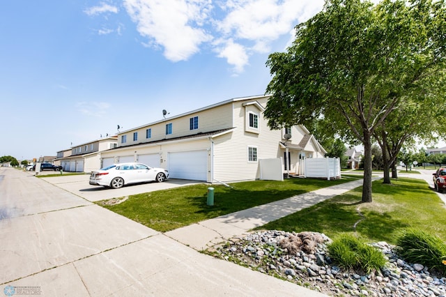 2383 58th Ave S Unit A, Fargo, ND 58104 - view of front of property featuring a front lawn, a garage, driveway, and a residential view