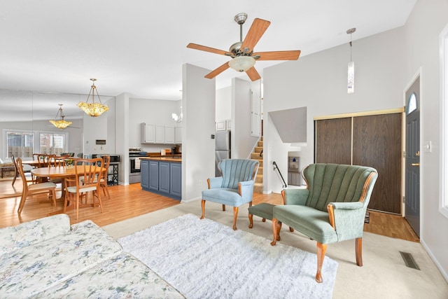 2304 Wildwood Trl, Minnetonka, MN 55305 - living room featuring stairs, ceiling fan, light wood-style floors, and light colored carpet
