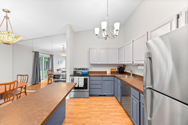 2304 Wildwood Trl, Minnetonka, MN 55305 - kitchen with appliances with stainless steel finishes, dark countertops, a chandelier, and decorative light fixtures
