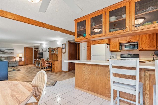 3864 Archie Dr SW, Alexandria, MN 56308 - kitchen with freestanding refrigerator, stainless steel microwave, range, light countertops, and a peninsula