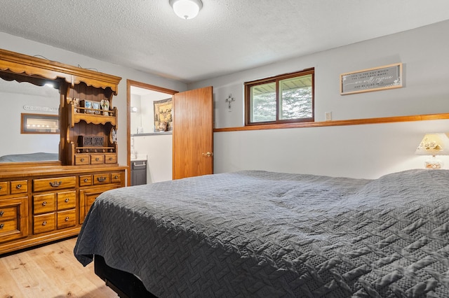 3864 Archie Dr SW, Alexandria, MN 56308 - bedroom featuring wood finished floors, a textured ceiling, and connected bathroom